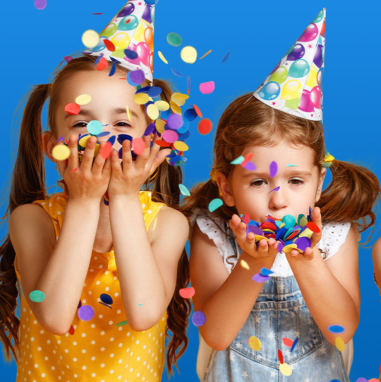 2 girls blowing confetti